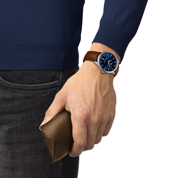 Hand wearing a blue-faced watch holding a brown leather wallet.