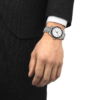 Elegant wristwatch on a person's wrist with a black outfit.